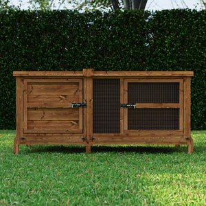 Wooden rabbit hutch on grass with green hedge in the background