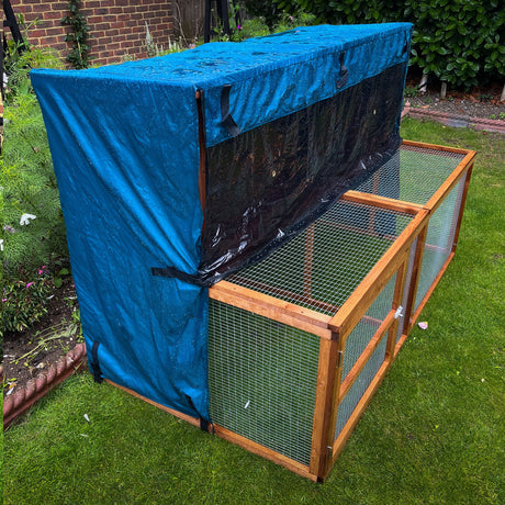 6ft kendal rabbit hutch and run rain cover in a dark garden about to rain