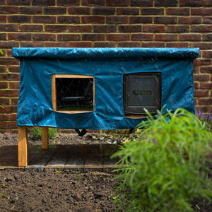 XL cat house rain cover in the garden under a cloudy sky in the garden