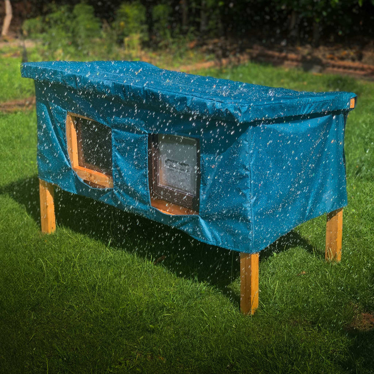 XL cat house rain cover in the garden under a cloudy sky front window